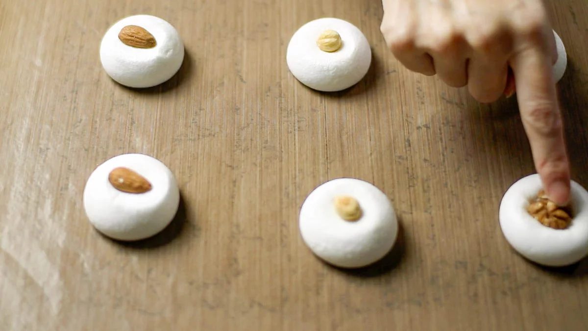 Place nuts gently on top of the softened marshmallows, pressing lightly.

Place them back in the oven at 120°C (250°F) for 45 minutes. Once removed from the oven, the marshmallow cookies will be soft, so let them cool directly on the baking sheet.
予熱した120度のオーブンで15分焼きます。