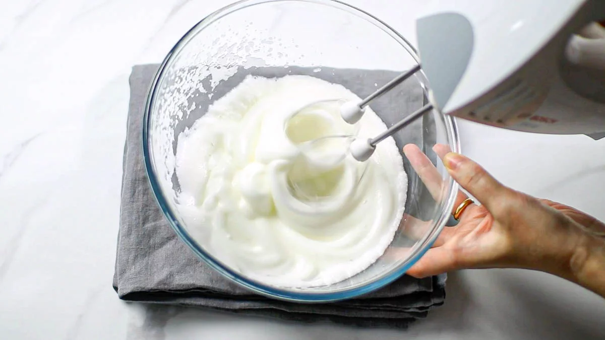 In a separate bowl, place the egg whites and beat until stiff peaks form.