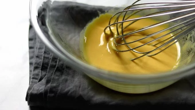 Add half the granulated sugar (50 g) to the egg yolks and mix well with a whisk until white