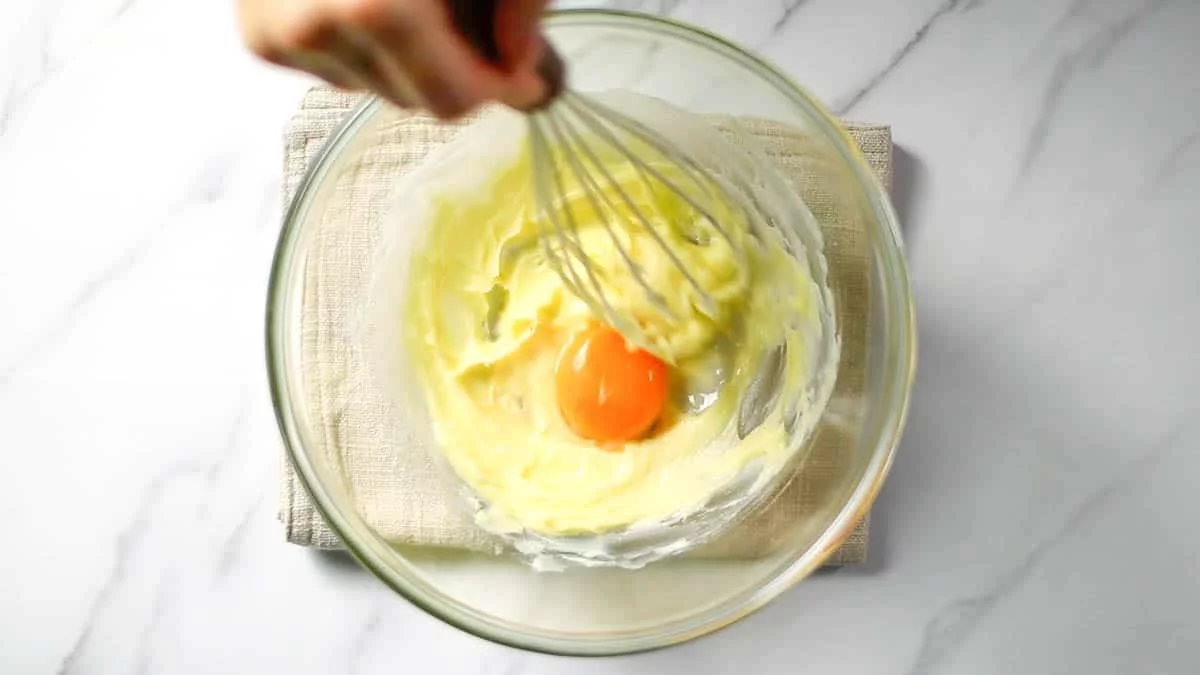 Add room temperature butter to a bowl and knead it to soften. Add powdered sugar and mix well until creamy.

Add the combined egg yolk and water mixture and mix thoroughly to combine.