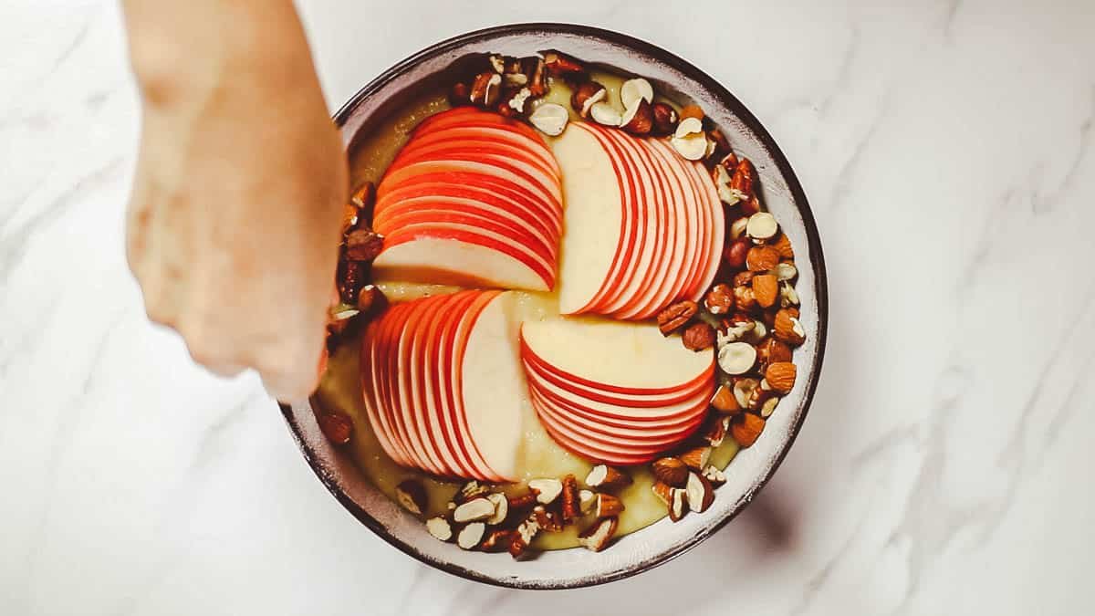 Place sliced apples in the center of the top of the dough, alternating lengthwise and crosswise Sprinkle nuts around the apples and bake in a 175°C oven for 35 minutes