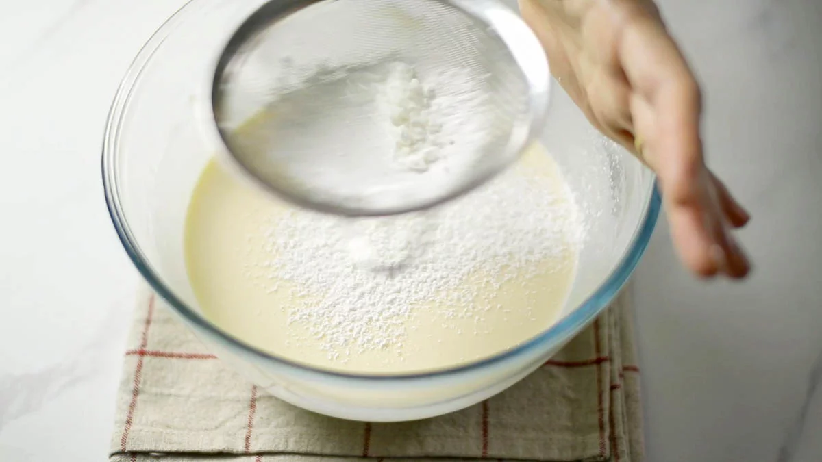 Add vanilla extract and sift in cornstarch.