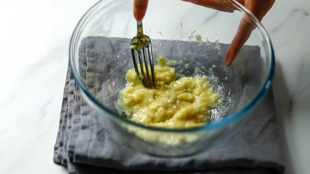 Put the bananas in a bowl and mash them with a fork