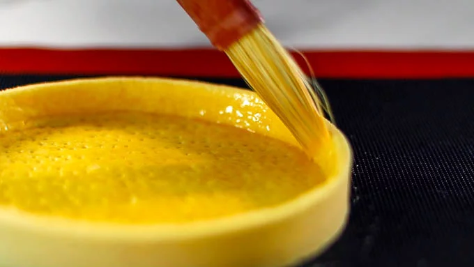 卵の黄身に生クリーム（または牛乳）を加えて溶きのばし、ハケでタルトの表面に塗っていきます。タルトの内側・外側にも塗ります。