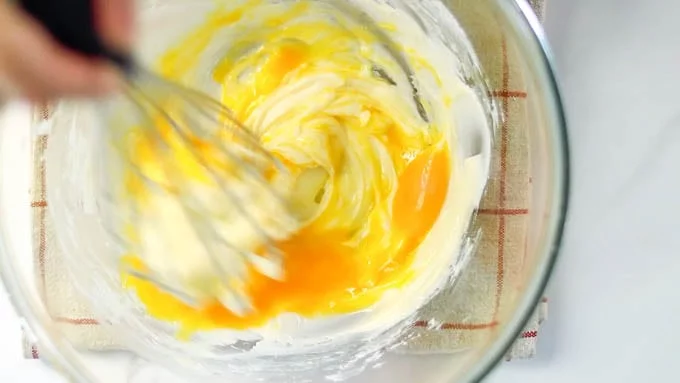 卵黄と水を合わせたものを加え、よく混ぜ合わせます。