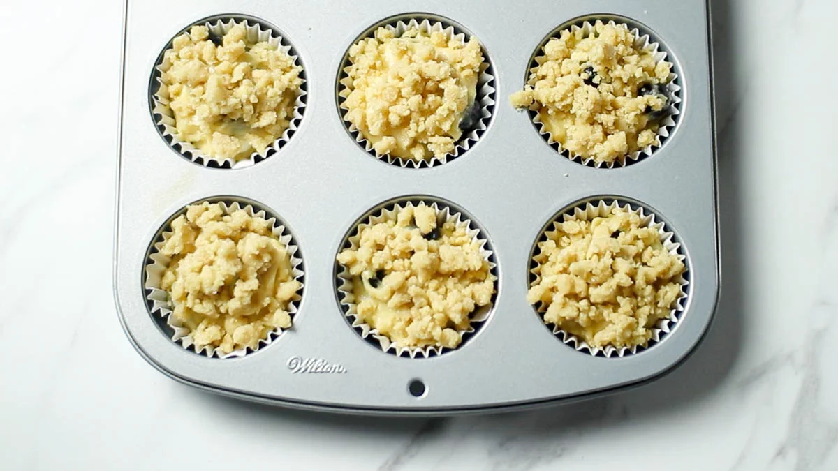 Fill the muffin batter on top until the cheesecake filling is covered (about 8/10 full). 

Top with crumble and bake in a preheated oven at 175°C (350°F) for about 20 minutes.