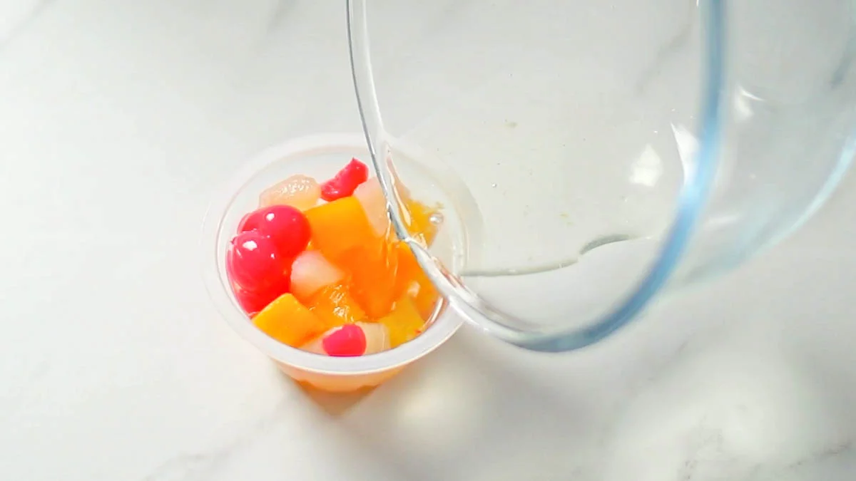 カップにフルーツを入れ、シロップを注ぎ入れます。冷蔵庫で2時間以上、よく冷やします。