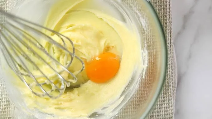卵黄と水を合わせたものを加え、よく混ぜ合わせます。