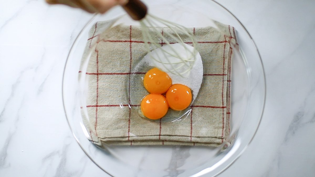 ボウルに入れた卵黄にグラニュー糖（35g）を加えて混ぜます。