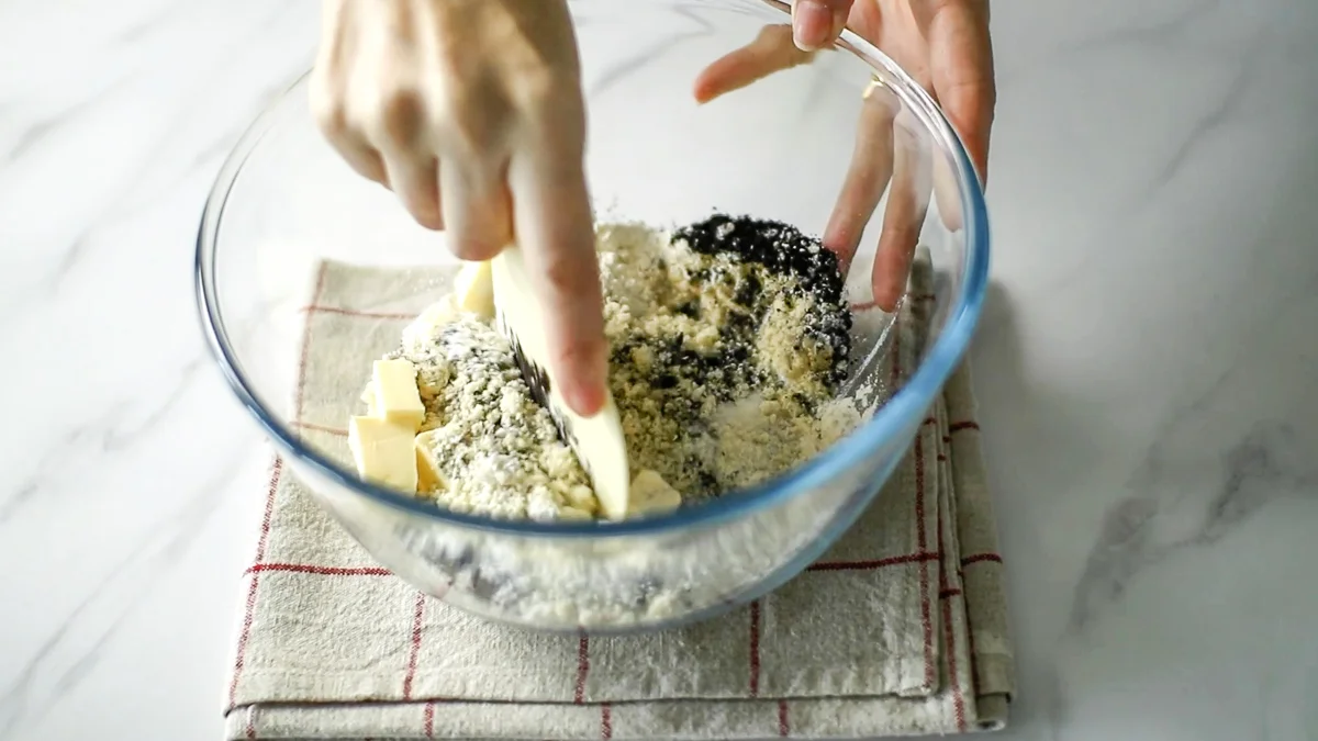 ボウルにグラニュー糖、薄力粉、ブラックココアパウダー、アーモンドパウダー、無塩バターを入れてスケッパーでバターを刻むようにして混ぜ合わせます。