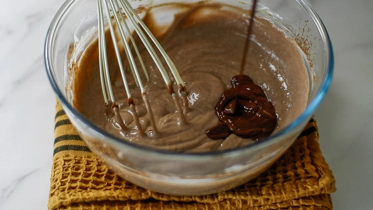 溶かしたチョコレートを加えます。（チョコレートは溶かしたばかりの少し温かい状態のものを加えて下さい。チョコレートが少し冷たい場合や、加えるチーズケーキ生地が冷たい場合は、チーズケーキ生地の一部をチョコレートに加えて混ぜ合わせてから加えて下さい。）