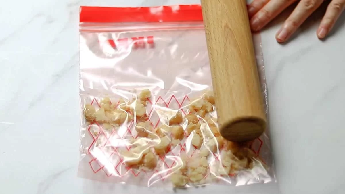 Crush the nuts by placing them in a bag and using a rolling pin to break them into larger pieces. It's fine to have bigger fragments to retain the texture.