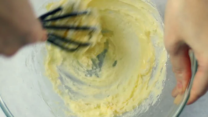 ボールに柔らかいバターとふるった粉砂糖を入れ、粉砂糖の粉っぽさがなくなるまで混ぜます。