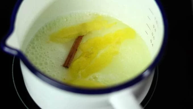 シロップを作ります。小鍋にグラニュー糖、水、シナモンスティック、レモンの皮を入れて火にかけ、沸騰させてグラニュー糖を溶かします。