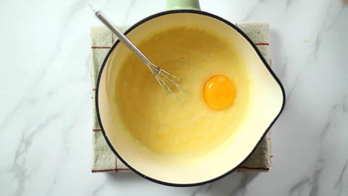 卵黄をひとつづつ加えてよく混ぜます。