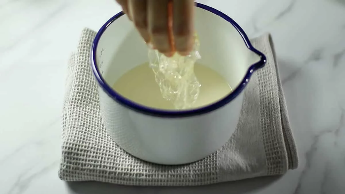 ゼラチンを溶かすために生クリームを温めます。（ゼラチンは手の熱で溶けるくらい融点が低いので、沸騰させる必要はありません）柔らかくなったゼラチンの水気をよく切って、生クリームに加え溶かします。（粉ゼラチンの場合はゼラチンと合わせた水ごと加えます）チーズケーキ生地に少しづつ加えてよく混ぜ合わせます。