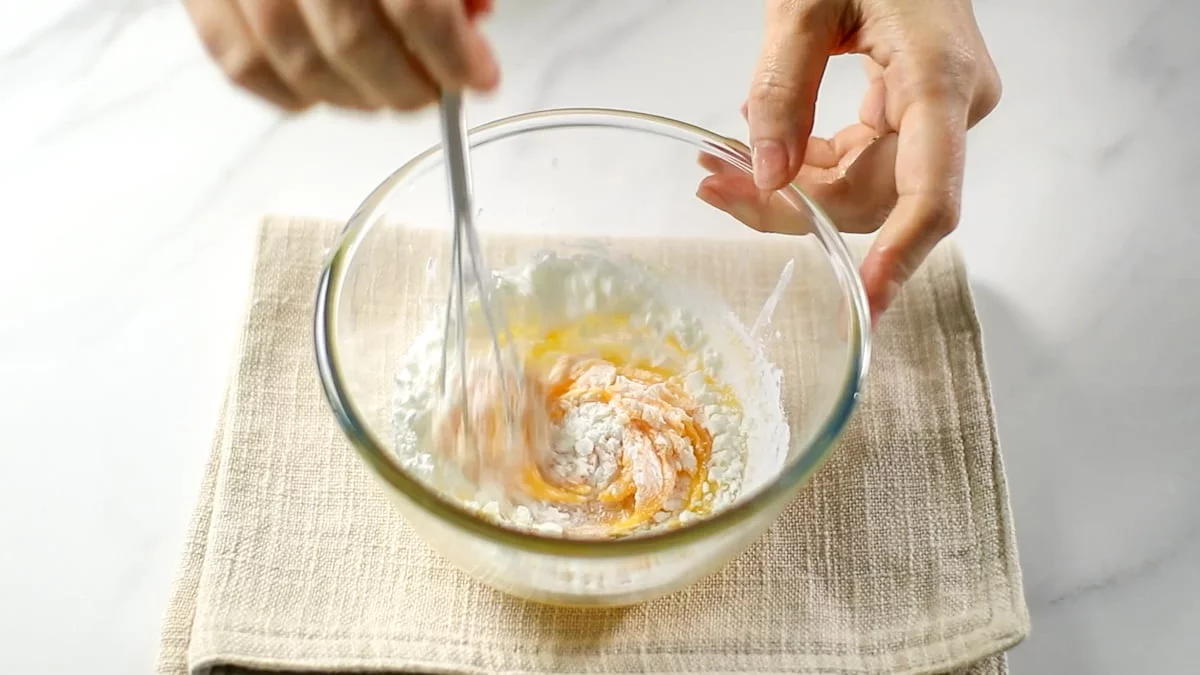 ボールに卵黄とグラニュー糖、コーンスターチを入れてホイッパーでよく混ぜ合わせます。