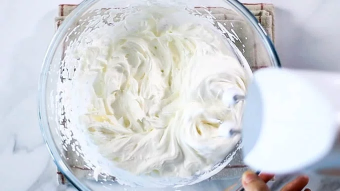 しっかりと泡立ってきたらクリームチーズを少しづつ加えて泡立て続けます。ホイップクリームのようにしっかりしたクリームになるまで泡立てます。