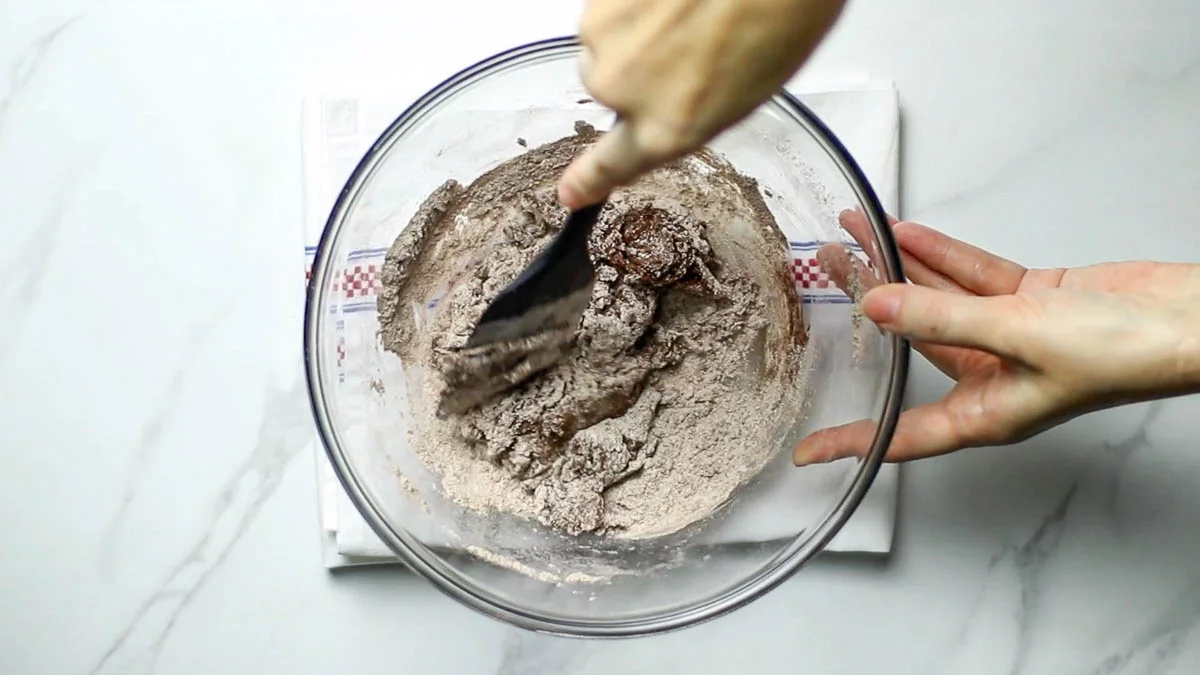 Sift in flour and cocoa powder.

Wrap the dough in plastic wrap and let rest in the refrigerator for 30 minutes.