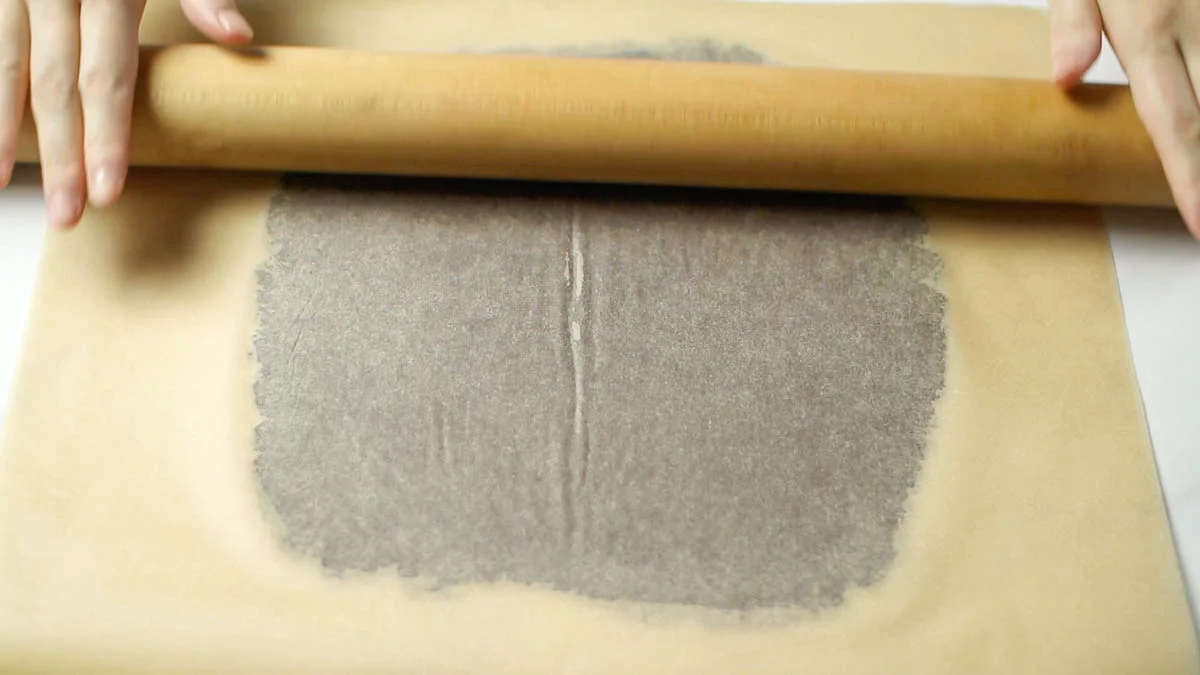 Prepare two large baking sheets and place the dough between them. Use a rolling pin to roll it out to a thickness of about 3mm (0.12 inches).
