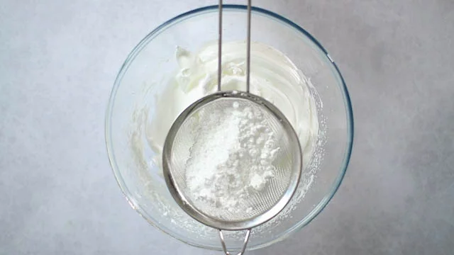 ふるった粉砂糖を2回に分けて加え、泡をつぶさないように気をつけながらメレンゲに混ぜ込みます。