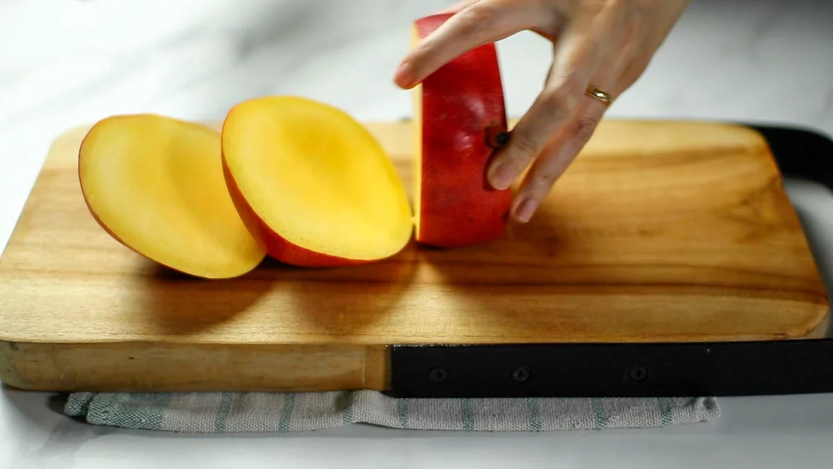 Mangoes contain a large oval seed in the center The seeds are horizontally placed on the flat side of the fruit, so place the fruit on a cutting board with the narrow side up and cut it into three pieces lengthwise