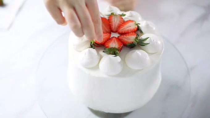 絞れる固さに調節したクリームを丸口金をつけた絞り袋に入れ、上面にデコレーションします。カットしたいちごを並べて花を飾り出来上がりです。カットする前に冷蔵庫に1時間ほどおいてクリームを冷やし固めてください。