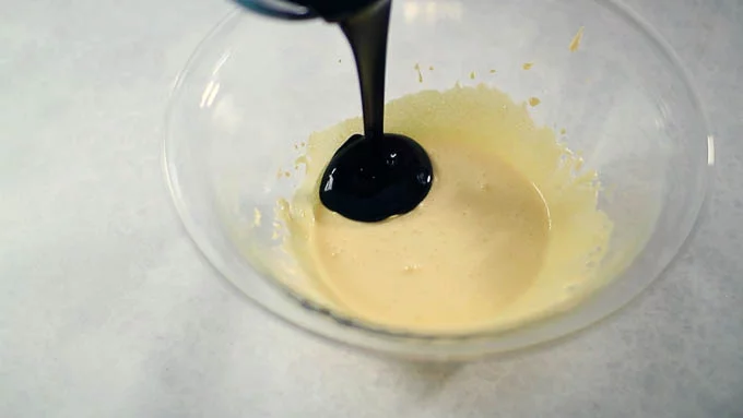 卵黄に残りの砂糖（30g）を加えて白っぽくなるまで混ぜ、先ほどの溶かしたチョコレートとバターを加え混ぜ合わせます。