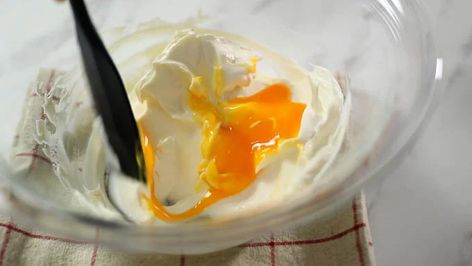 卵を卵黄と卵白に分け、卵白は泡立てるまで冷蔵庫に入れておきます。卵黄を1. に加えて混ぜ合わせます。