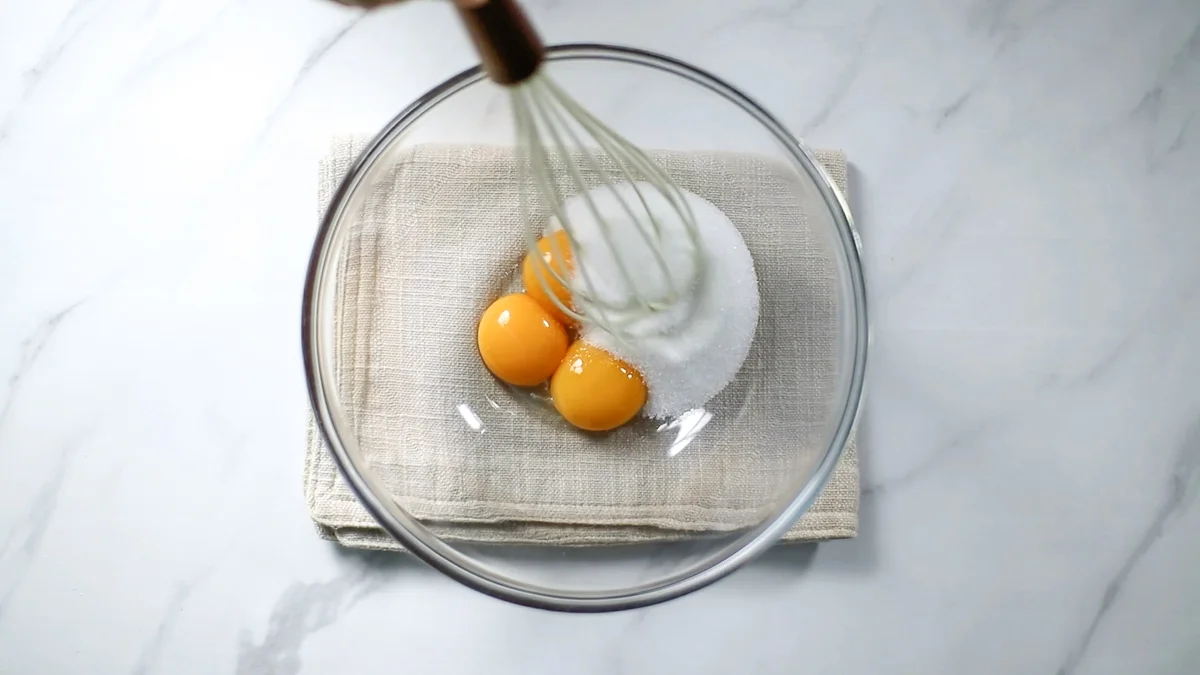 ボウルに卵黄とグラニュー糖を入れてホイッパーで混ぜ合わせ、コーンスターチをふるい入れ混ぜ合わせます。