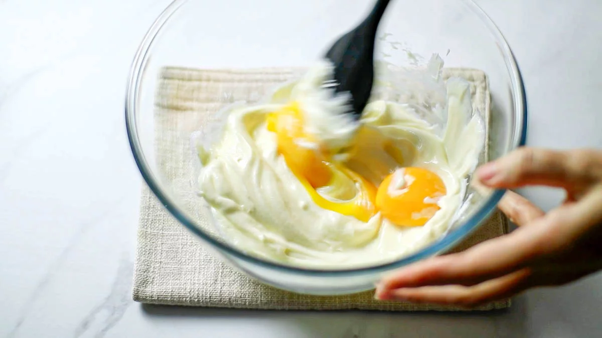 卵黄を加えて混ぜ、薄力粉をふるい入れます。