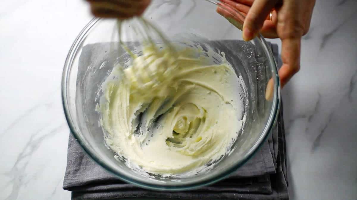 ボウルに柔らかくなったバターを入れ、粉砂糖をふるい入れます。ホイッパーまたはゴムべらでなめらかになるまでよく混ぜ合わせます。