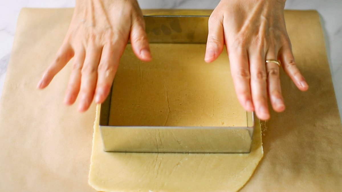 クッキングシートを敷き、生地を置いて上にラップをのせ、厚さ2mmにのばします。

15cm角の型を使ってスクエアにカットし、予熱した160℃のオーブンで約20分焼きます。