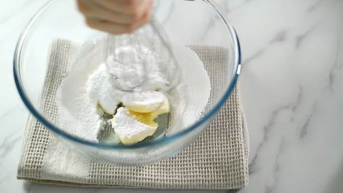 ボールに室温に戻したバターを入れて練って柔らかく戻し、粉砂糖を加えてよくすり混ぜます。