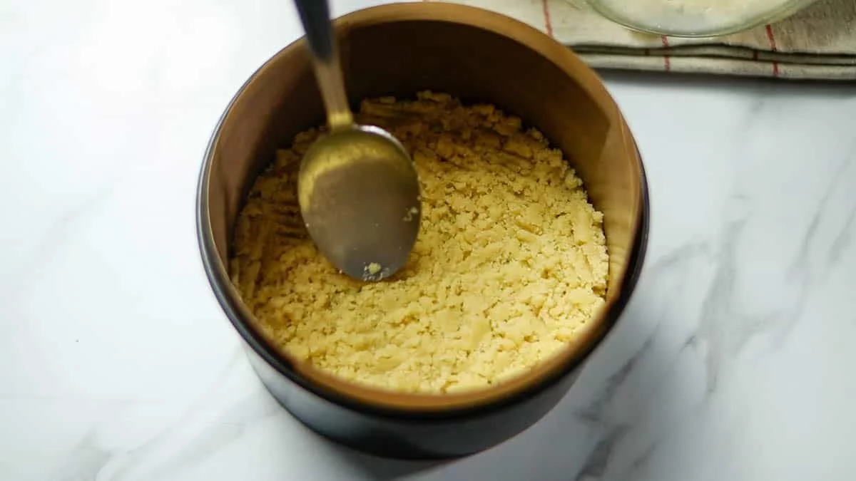 Pour approximately half of the crumble mixture into the baking pan, covering the bottom evenly using the back of a spoon or any flat surface. Keep the remaining half of the crumble mixture in the refrigerator until ready to use.