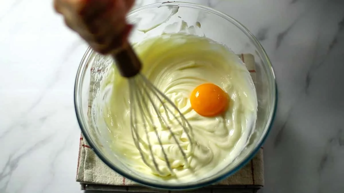 Add one egg yolk, mixing well each time