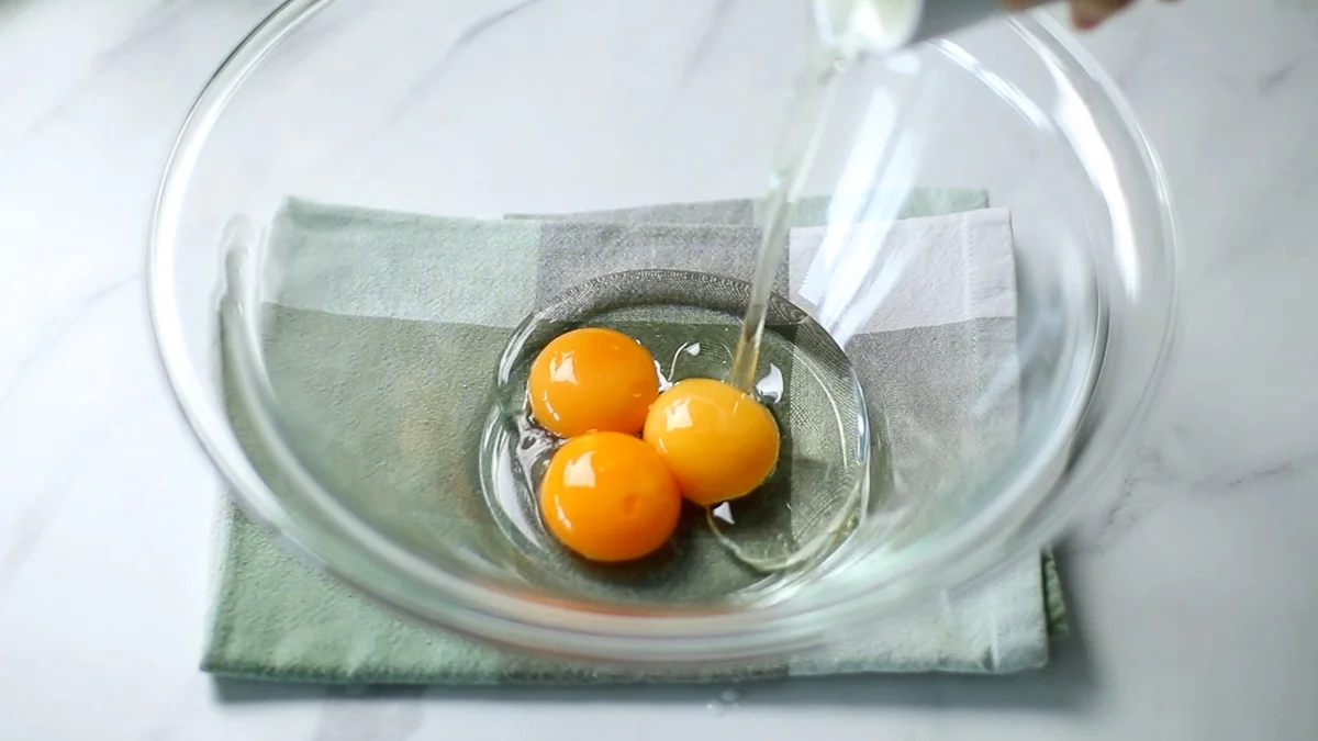 卵黄に植物油を加えてホイッパーで混ぜ合わせます。