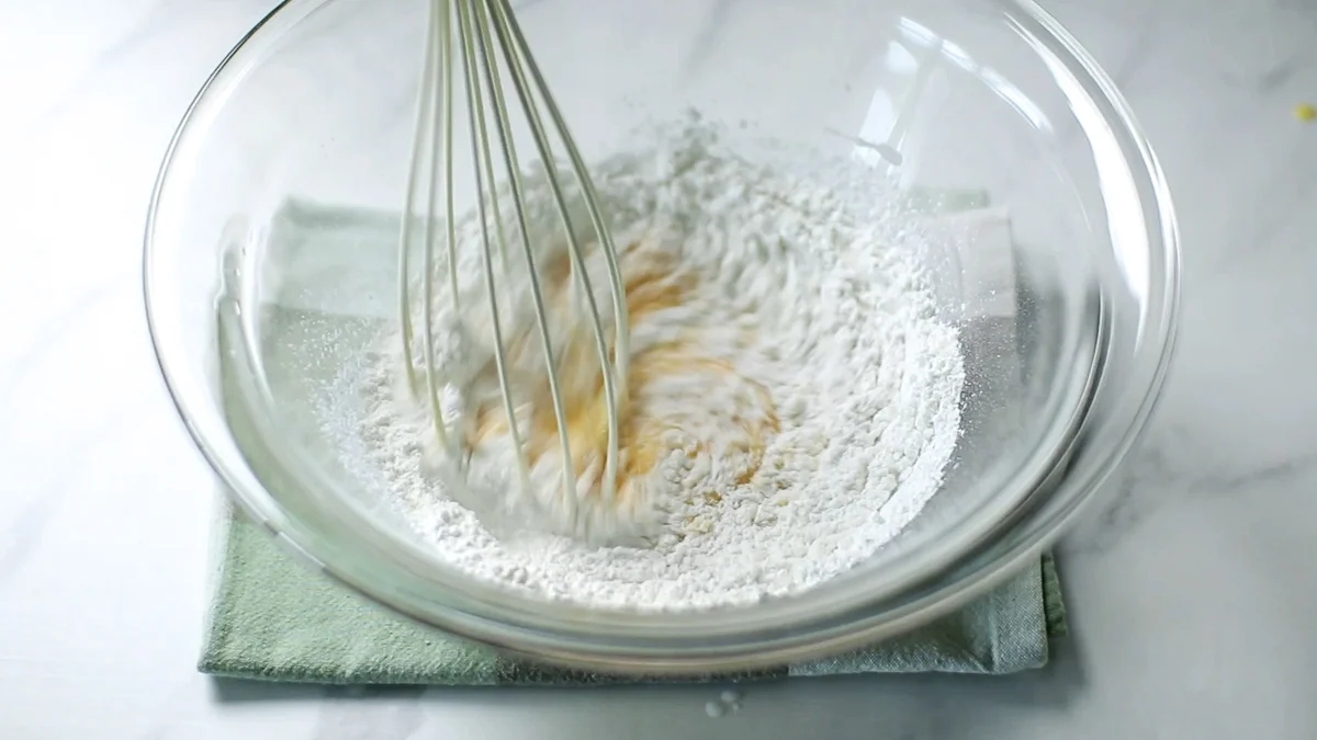 米粉をふるい入れ、ホイッパーで混ぜ合わせます。