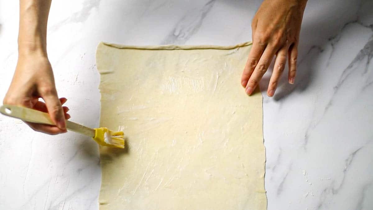 Using a brush, apply a thin layer of lard to the entire top of the rolled portion of the dough