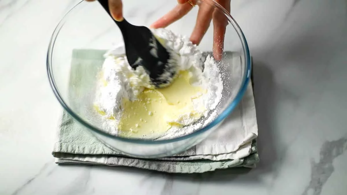ボールに柔らかいバターとふるった粉砂糖を入れ、粉砂糖の粉っぽさがなくなるまで混ぜます。