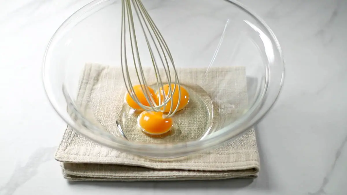 In a bowl, mix the egg yolks with the vegetable oil