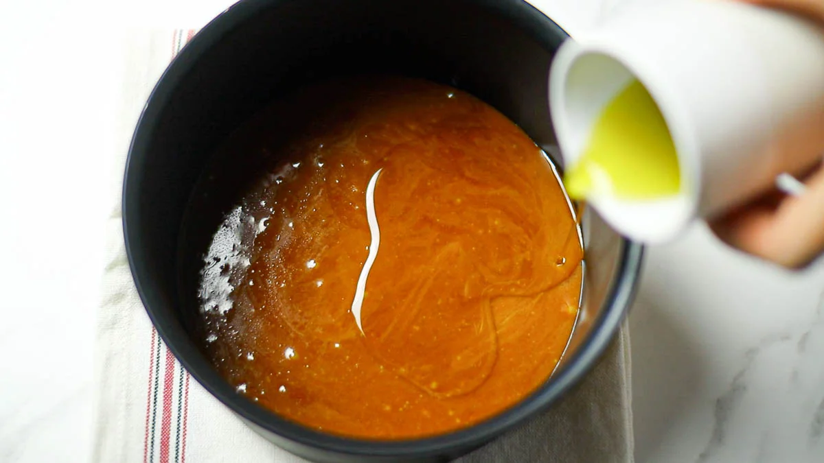 Pour the caramel into the mold Wait 5 minutes for it to cool, then pour in half the olive oil (20 ml)