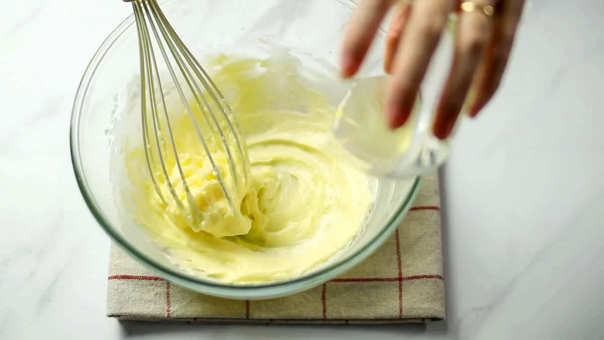 卵白を少しづつ加えて混ぜあわせます。卵白だけだとバターを混ざりあいにくいので、少しづつ加えてその都度よく混ぜてください。