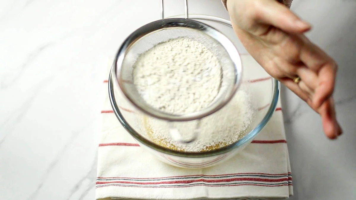 薄力粉とベーキングパウダー、塩をふるい入れ、ゴムベラでさっと混ぜます。
