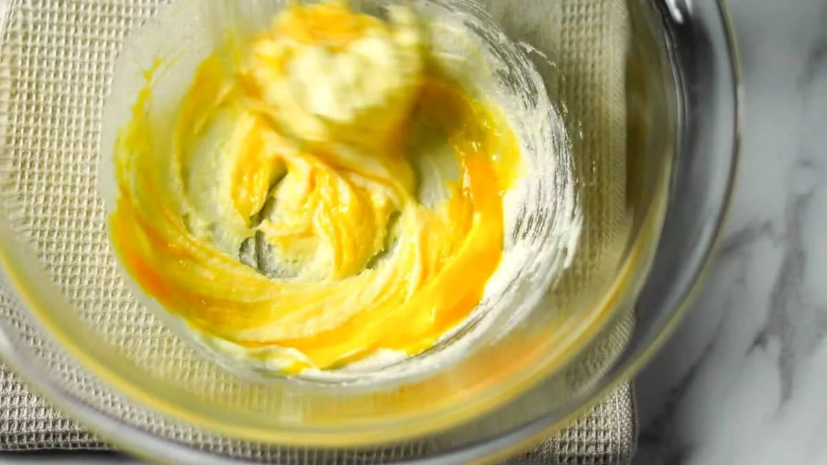 柔らかいバターをボウルに入れ、グラニュー糖を加えて白っぽくなるまでよく混ぜます。卵黄を加えてよく混ぜ合わせます。