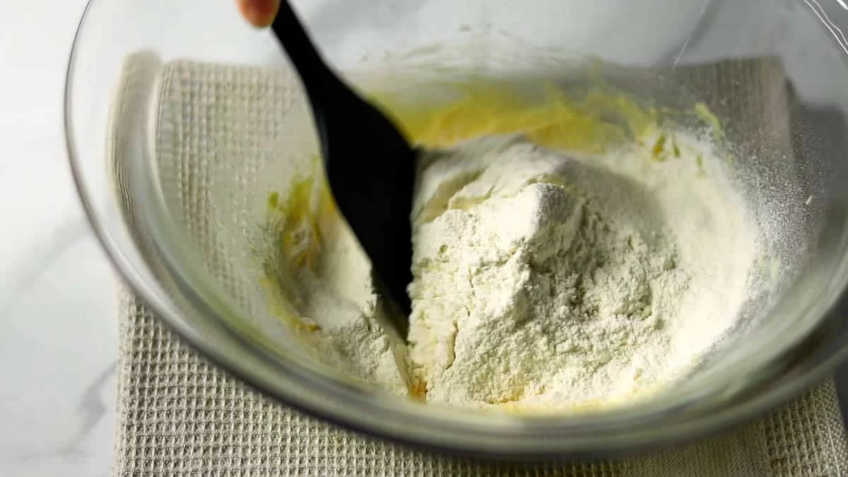 薄力粉とベーキングパウダーをふるい入れ、塩も加えてゴムベラでさっくりと混ぜ合わせます。
