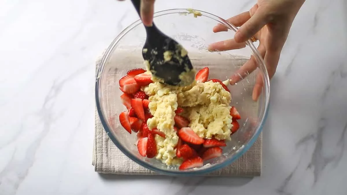 Add the cut strawberries and mix Be careful not to overmix the strawberries, as they will release water and make the dough messy When the dough and strawberries are roughly blended, it is ready
