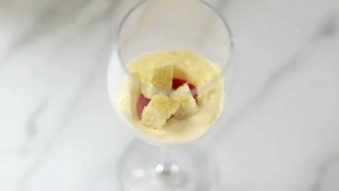 グラスの底にマスカルポーネクリームを少量入れ、スプーンなどで中央に穴をあけます。
穴を作ったところにいちごのピュレを入れ、上から角切りにしたスポンジケーキを入れます。