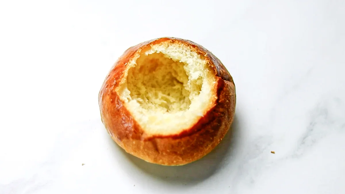 パンの上部を切り落とし、パンの中央を丸くくり抜きます。（くり抜いたパンはアーモンドフィリングに混ぜておきます。）