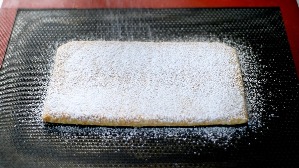 予熱した180度のオーブンで20分ほど焼きます。

途中、パイ生地が膨らんできたら焼き網などを上に乗せて膨らみを抑え、目の詰まった固めのパイ生地を作ります。

焼き色がついたらオーブンから取り出し、全体に薄く粉砂糖をふりかけます。次に、オーブンを240度に予熱し、パイ生地を再びオーブンに入れて1〜2分ほど焼き、パイ生地の表面をキャラメリゼします。（※砂糖はすぐに溶け始めるので、オーブンのそばを離れず、様子を見ながらキャラメリゼしてください。）
